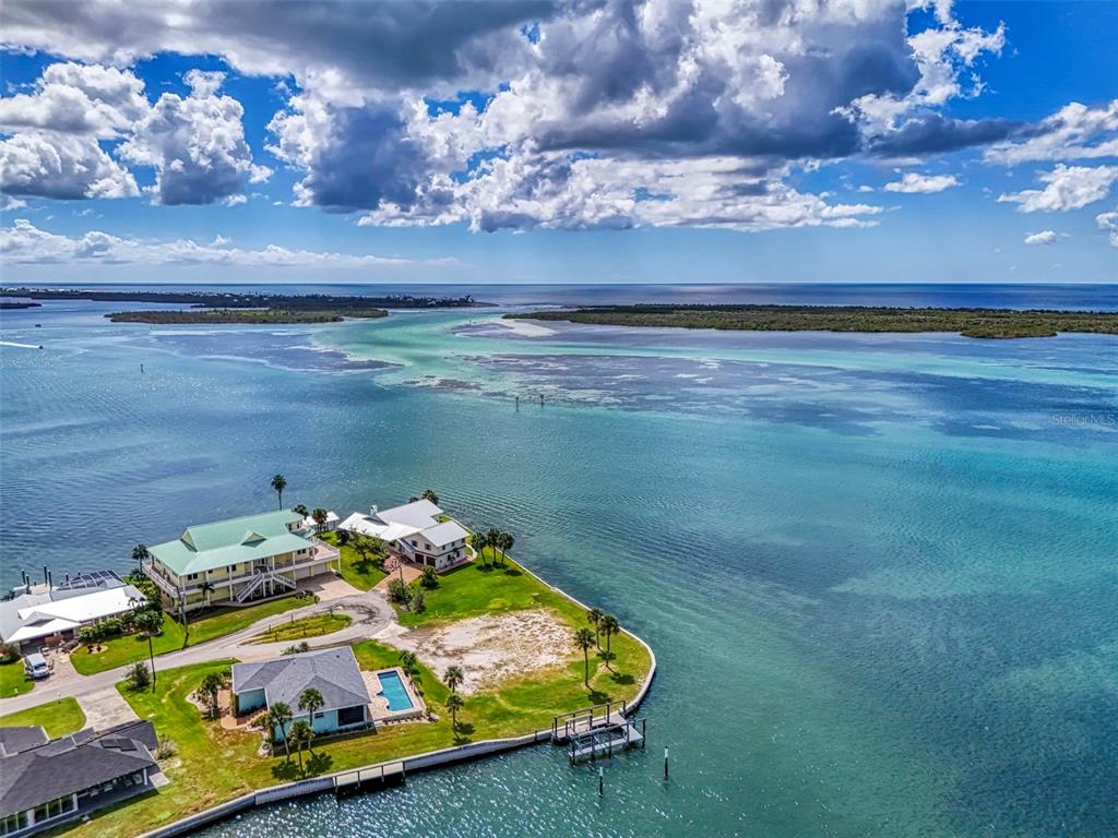 An aerial view shows waterfront houses on a grassy point with a private dock — 1962 ARKANSAS AVENUE, ENGLEWOOD, FL