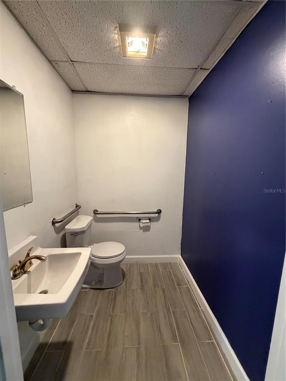 A small bathroom features a white pedestal sink, a toilet with grab bars, and tile flooring — 550 BALMORAL CIRCLE N UNIT 301/302, JACKSONVILLE, FL