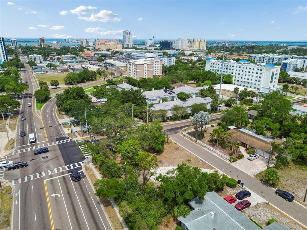 An aerial view shows a city intersection, surrounding residential buildings, and a vacant lot — 1107 BROWNELL STREET, CLEARWATER, FL