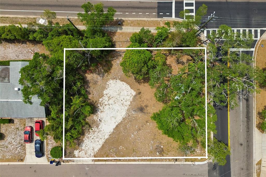 An aerial view shows a vacant, rectangular lot bordered by trees and paved roads — 1107 BROWNELL STREET, CLEARWATER, FL