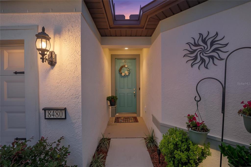 A teal front door with a wreath is centered at the end of a walkway — 8480 SW 52ND LANE ROAD, OCALA, FL