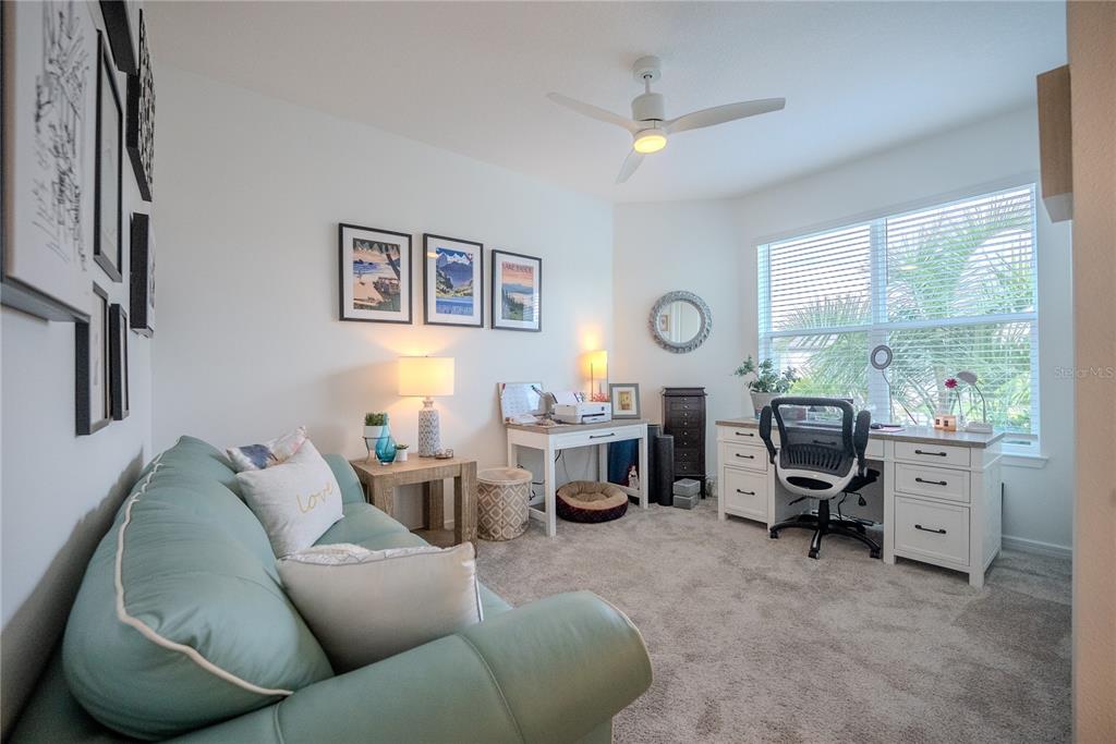 A home office features a light blue sofa, a white desk, and a ceiling fan — 8480 SW 52ND LANE ROAD, OCALA, FL