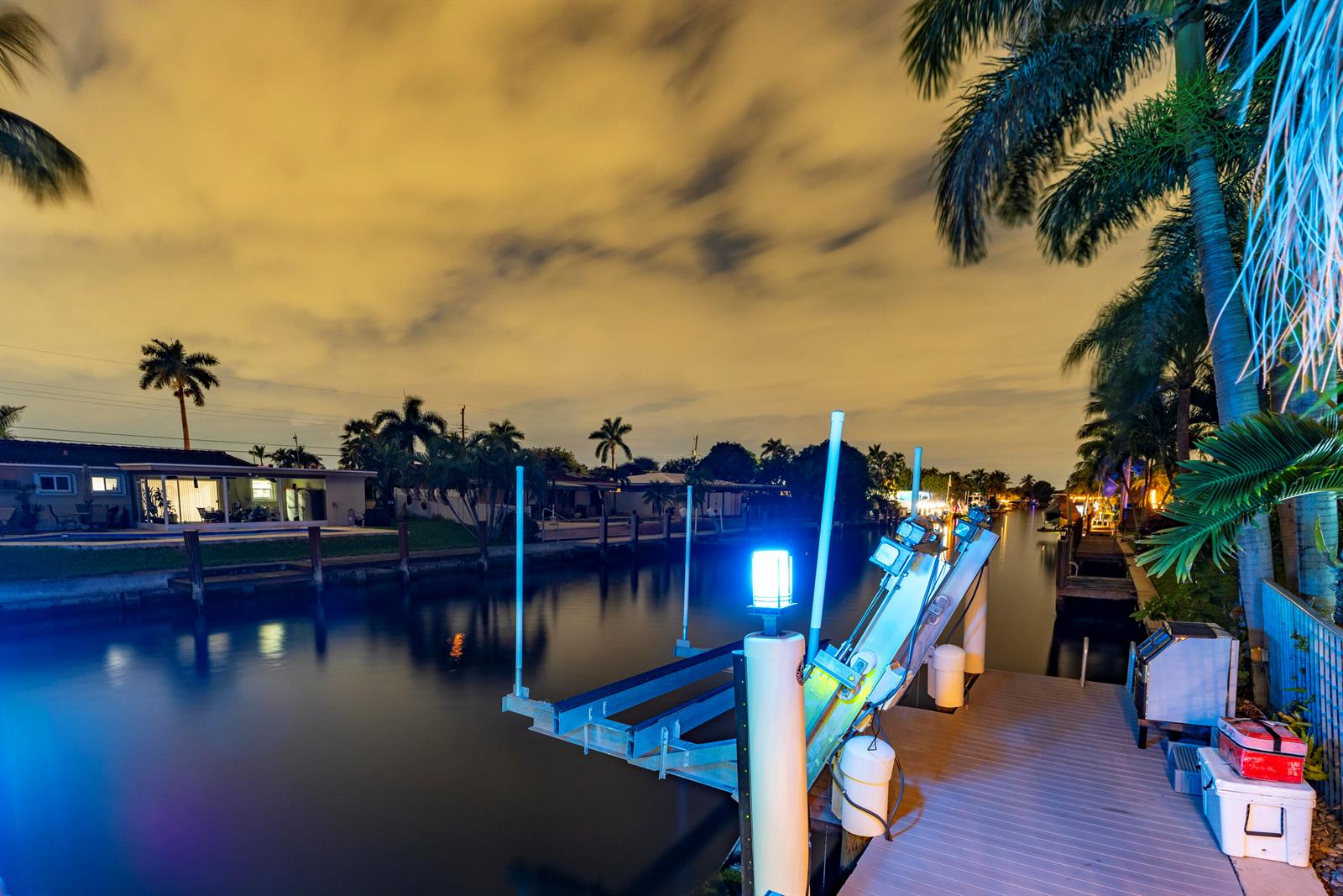 A boat lift sits on a wooden dock overlooking a canal at night — 851 SE 5th Avenue, Pompano Beach FL 33060, POMPANO BEACH, FL