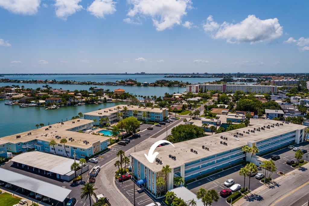 An aerial view shows a multi-story apartment building with a flat roof and parking lot — 6161 GULF WINDS DRIVE UNIT 338, ST PETE BEACH, FL