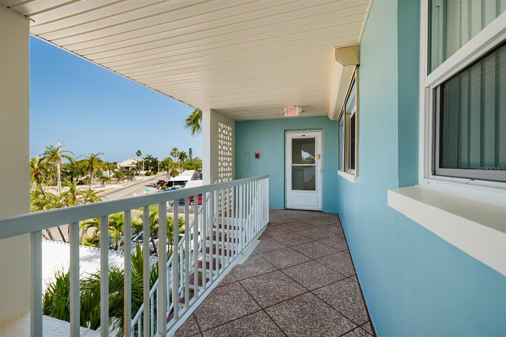 An outdoor balcony with light blue walls, a white railing, and a tiled floor — 6161 GULF WINDS DRIVE UNIT 338, ST PETE BEACH, FL