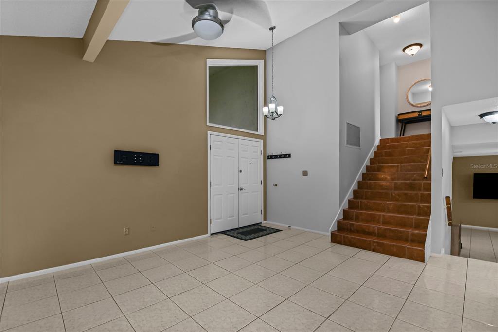 An entryway features tiled floors, a high ceiling, and a staircase with brown tiles — 1304 ORTEGA STREET, WINTER SPRINGS, FL
