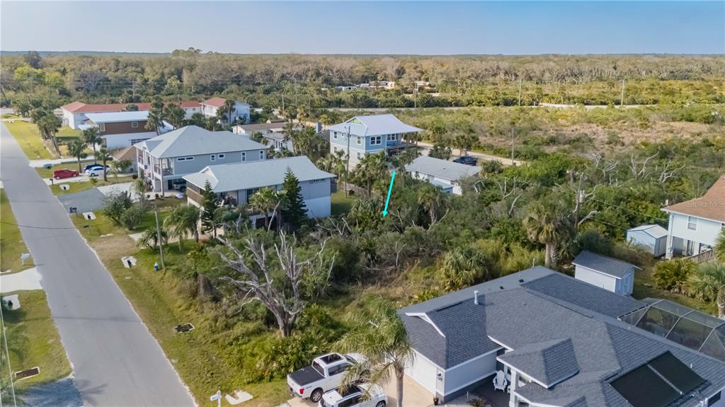 An aerial view shows a residential neighborhood with houses, a vacant lot, and vegetation — 15 OCEAN STREET, PALM COAST, FL