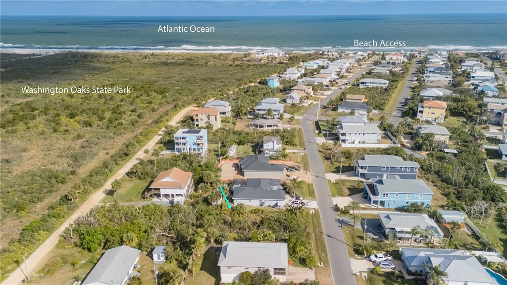 An aerial view shows a coastal neighborhood with houses, a road, and nearby state park land — 15 OCEAN STREET, PALM COAST, FL