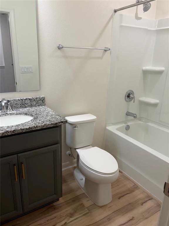 A bathroom features a gray vanity with a granite countertop, a toilet, and a tub-shower — 1492 MIRABELLA CIRCLE, DAVENPORT, FL