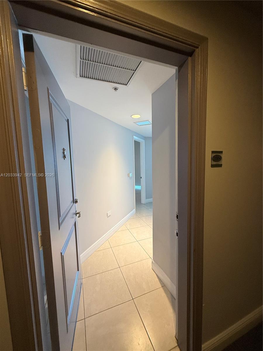 A doorway opens into a tiled hallway with light-colored walls and recessed ceiling lighting — 480 NE 30th St # 1504, Miami FL 33137, MIAMI, FL