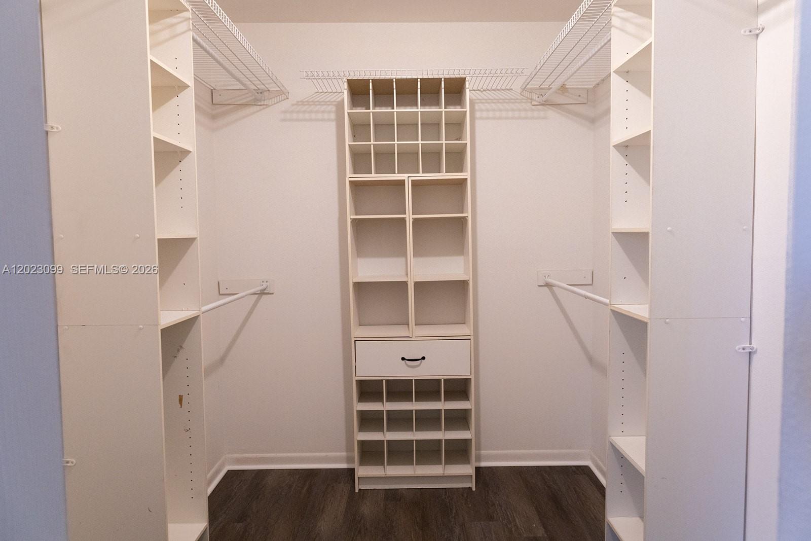 A walk-in closet features white shelving units, a central drawer, and wire hanging rods — 8018 SW 18th Ct # 8, Davie FL 33324, DAVIE, FL