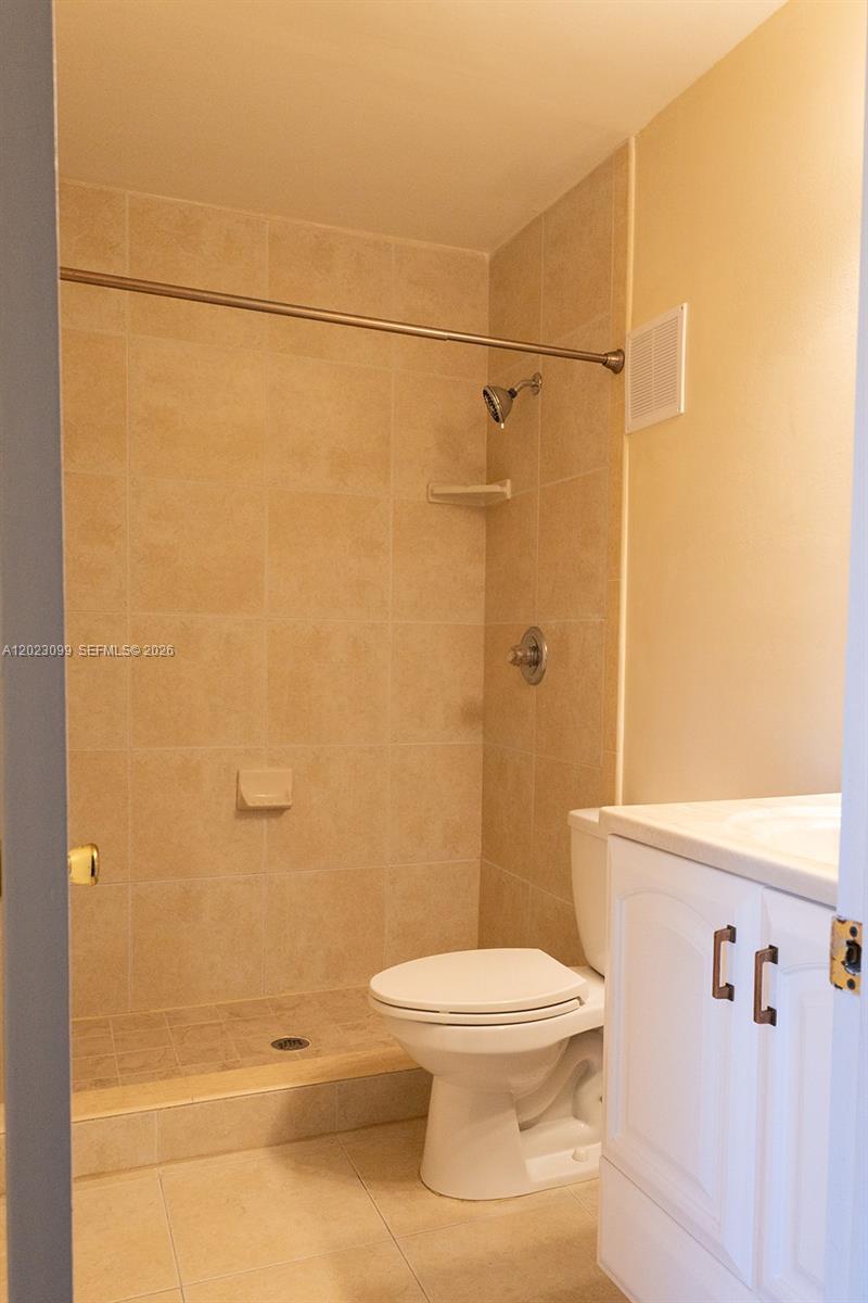 A bathroom features a tiled walk-in shower, a white toilet, and a white vanity cabinet — 8018 SW 18th Ct # 8, Davie FL 33324, DAVIE, FL