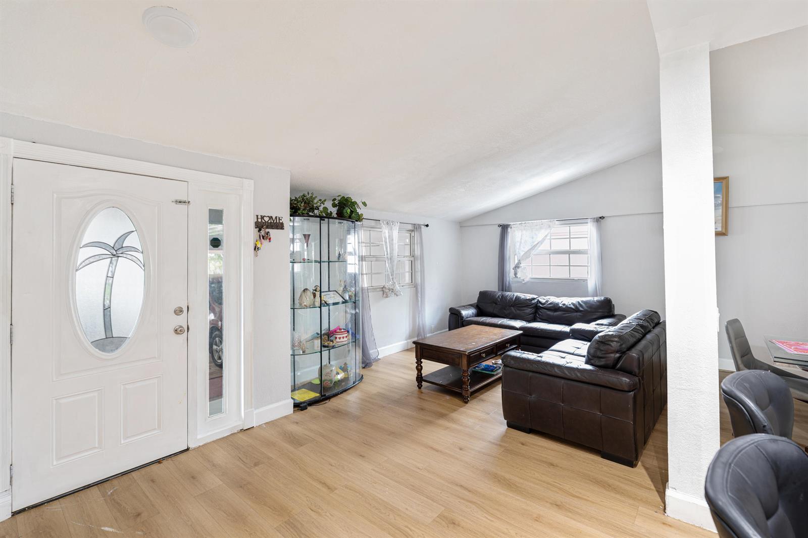 A living room features light wood flooring, a glass display cabinet, and dark leather sofas — 3872 Mackinac Road, FL 33462, FL