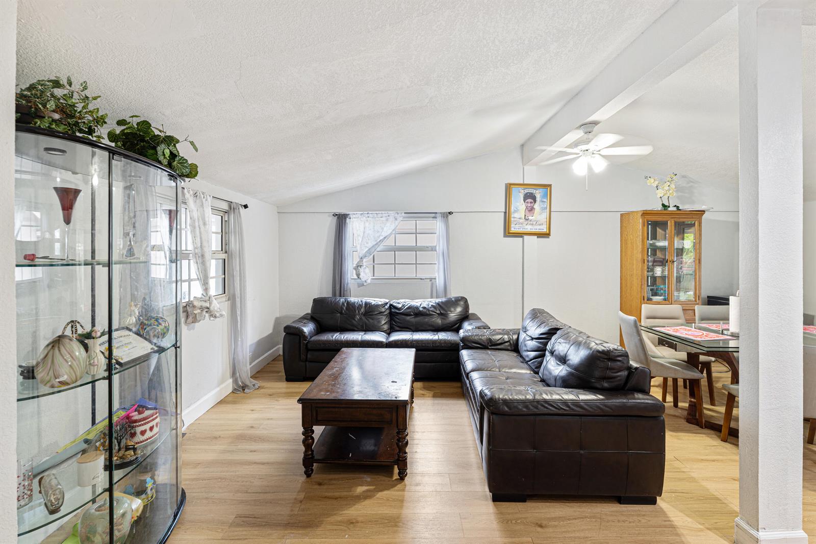 A living room features two black leather sofas, a wooden coffee table, and a glass display cabinet — 3872 Mackinac Road, FL 33462, FL