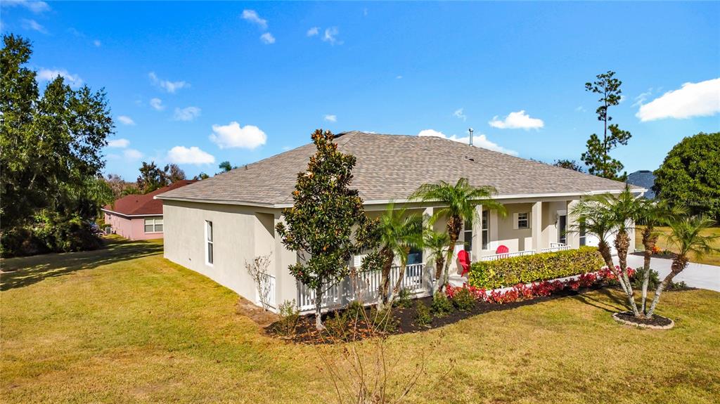 A single-story house with a beige exterior, a covered porch, and a landscaped front yard — 312 TOWHEE ROAD, WINTER HAVEN, FL