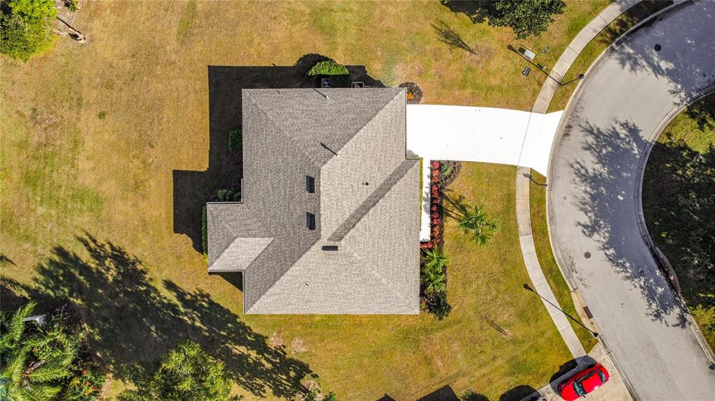 An aerial view shows a house with a gray shingled roof, driveway, and surrounding lawn — 312 TOWHEE ROAD, WINTER HAVEN, FL