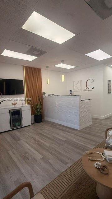 A bright reception area features a white desk, wood-slat wall paneling, and light wood flooring — 119 N POWERLINE RD # 119, Deerfield Beach FL 33442, DEERFIELD BEACH, FL