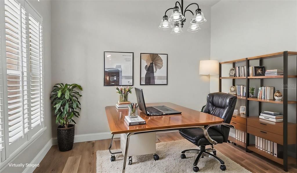 A home office features a wooden desk, black leather chair, bookshelf, and a chandelier — 530 BUCKSHOT LANE, LAKELAND, FL