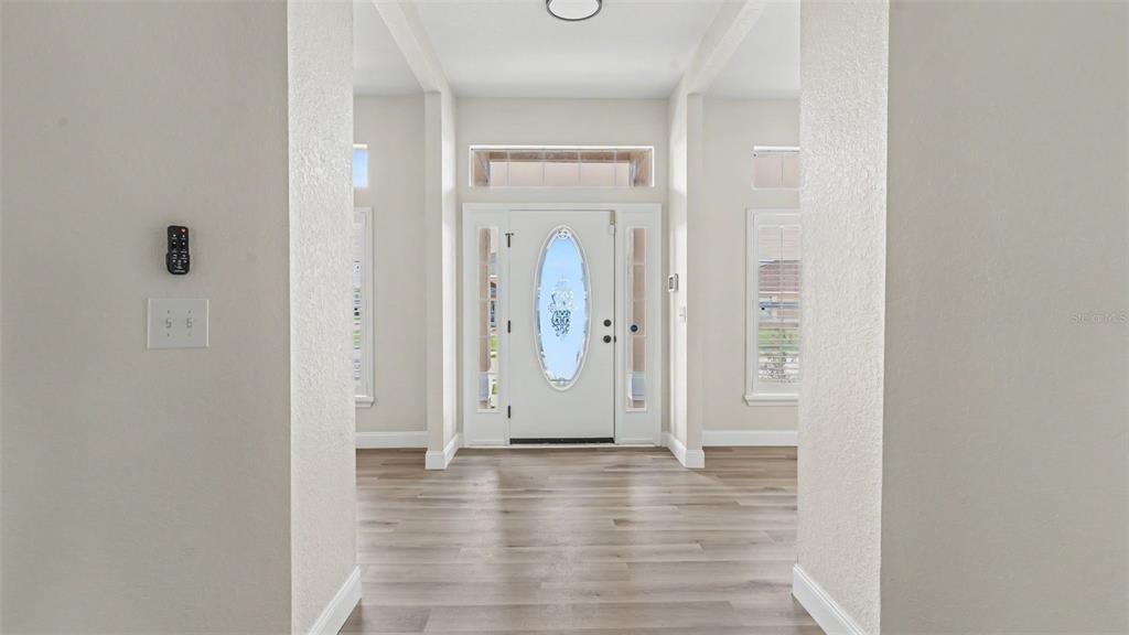 A bright entryway features light wood-look flooring, white walls, and a white front door — 530 BUCKSHOT LANE, LAKELAND, FL