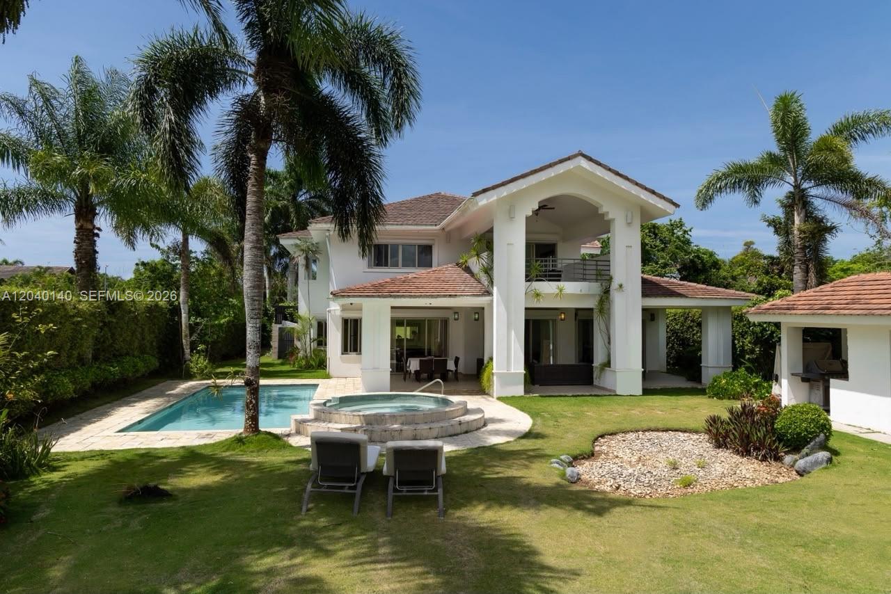 A two-story white house features a swimming pool, hot tub, and a covered patio area — 0 juan dolio, 0, FL