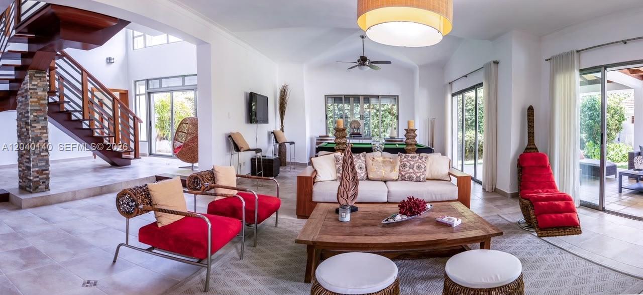 A spacious living room features a wooden staircase, a pool table, and red accent furniture — 0 juan dolio, 0, FL