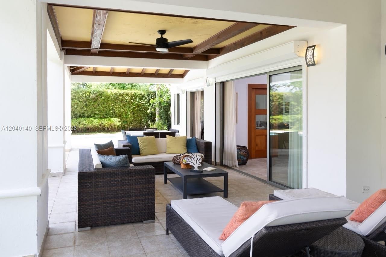 A covered outdoor patio features wicker furniture, a ceiling fan, and sliding glass doors — 0 juan dolio, 0, FL