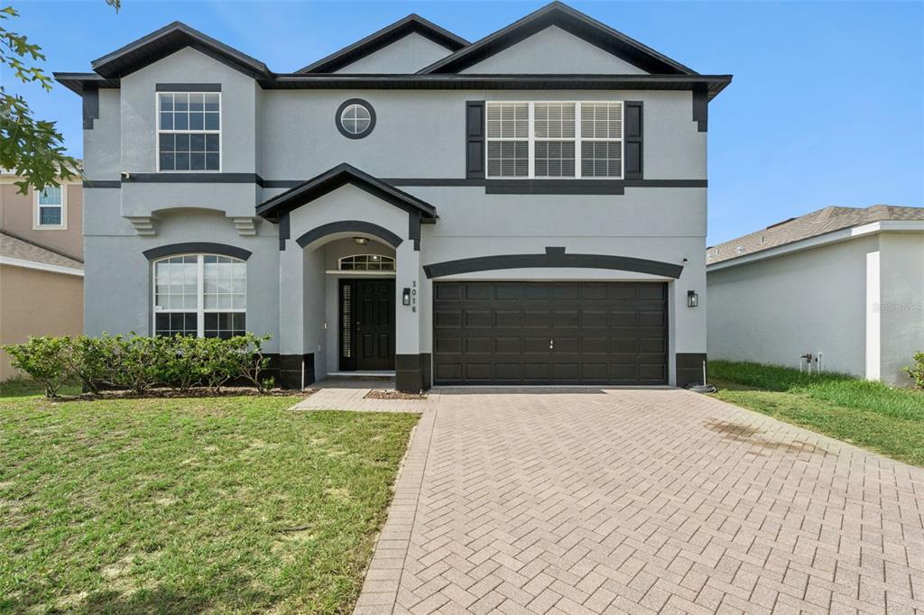A living room features a grey sofa, a black coffee table, and a dining area — 3016 SUNSCAPE TERRACE, GROVELAND, FL