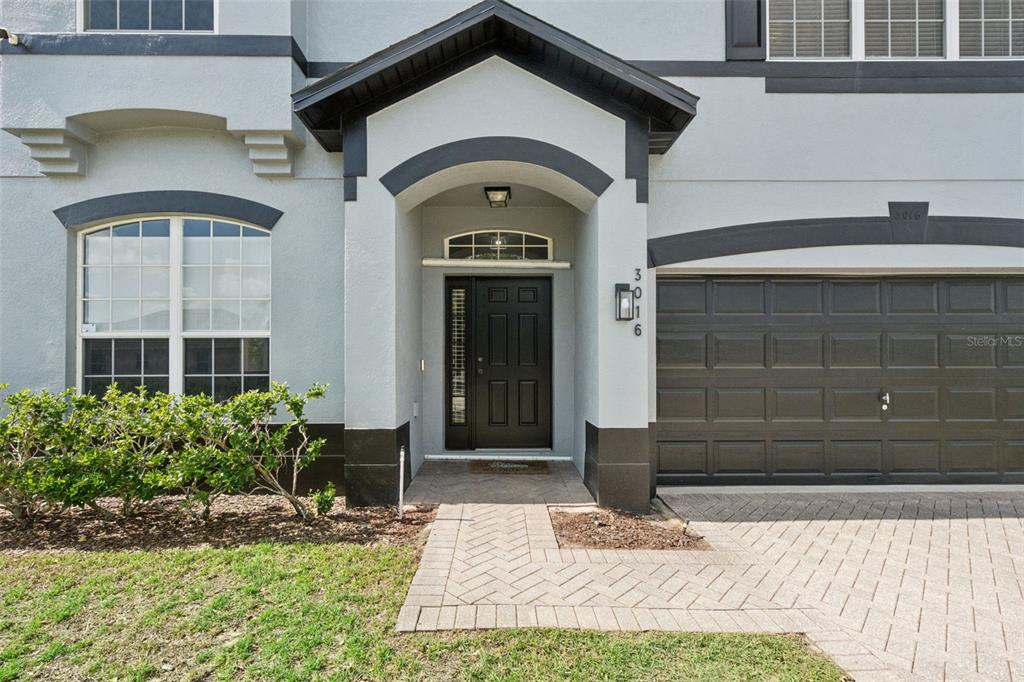 An open-concept dining and living area features light wood floors, blue walls, and modern furniture — 3016 SUNSCAPE TERRACE, GROVELAND, FL
