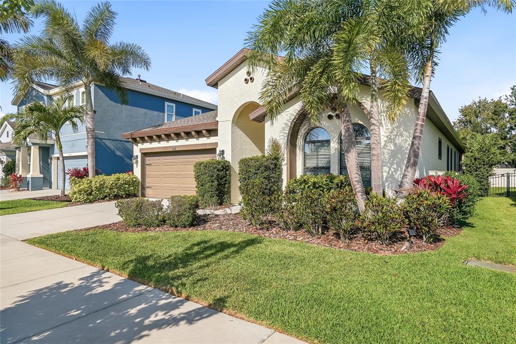A single-story stucco house with a two-car garage and palm trees in the front yard — 6318 SPRINGLINE PLACE, APOLLO BEACH, FL