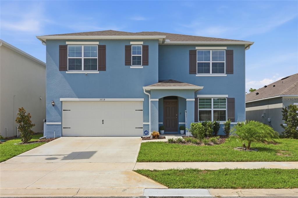 A two-story blue house with a two-car garage and a front porch — 3719 PARAGON LANE, CLERMONT, FL