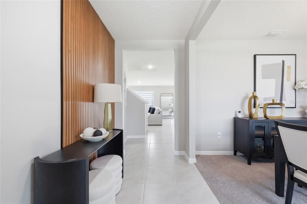 A hallway with a wood-slat accent wall leads to a living area with tiled floors — 3719 PARAGON LANE, CLERMONT, FL