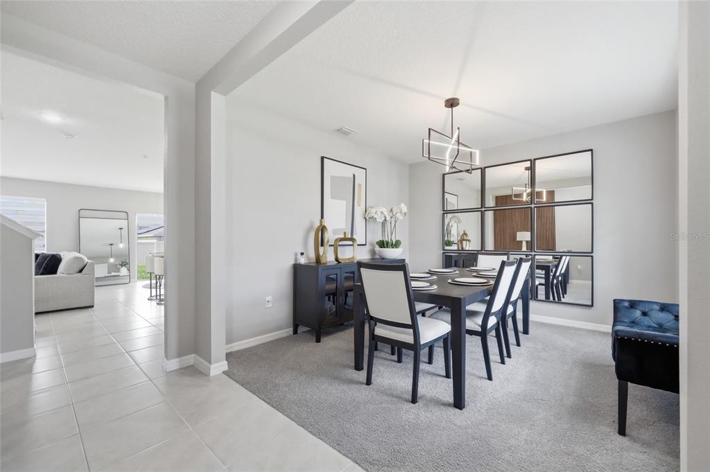 A dining room with a dark wood table, white chairs, and a large wall mirror — 3719 PARAGON LANE, CLERMONT, FL