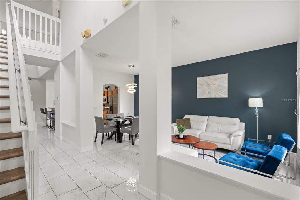 A view of a living room with a dark accent wall and an adjacent dining area — 4722 CUMBRIAN LAKES DRIVE, KISSIMMEE, FL