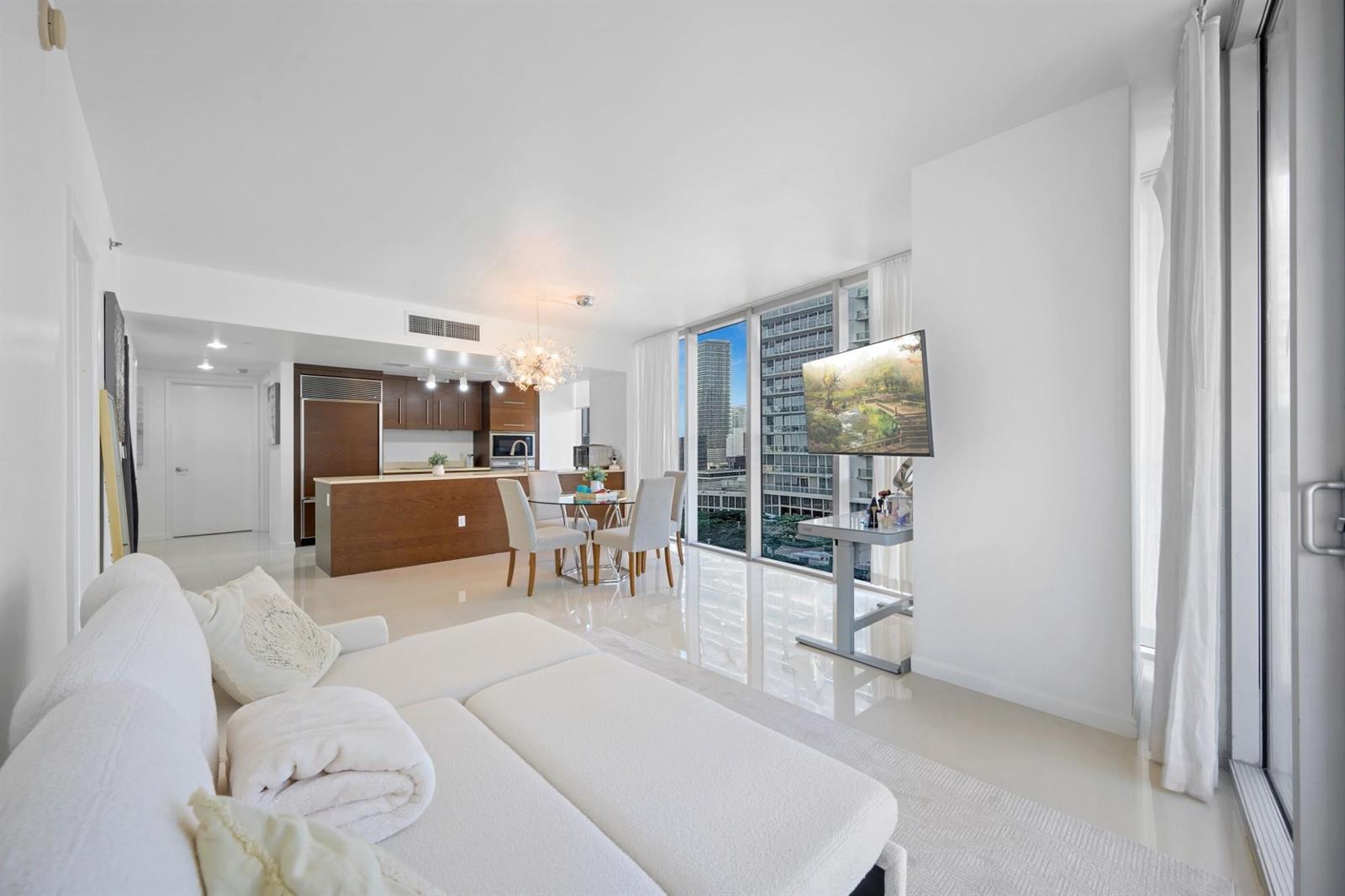 A modern living room with white tile floors, a dining area, and floor-to-ceiling windows — 475 Brickell Avenue # 1815, Miami FL 33131, MIAMI, FL