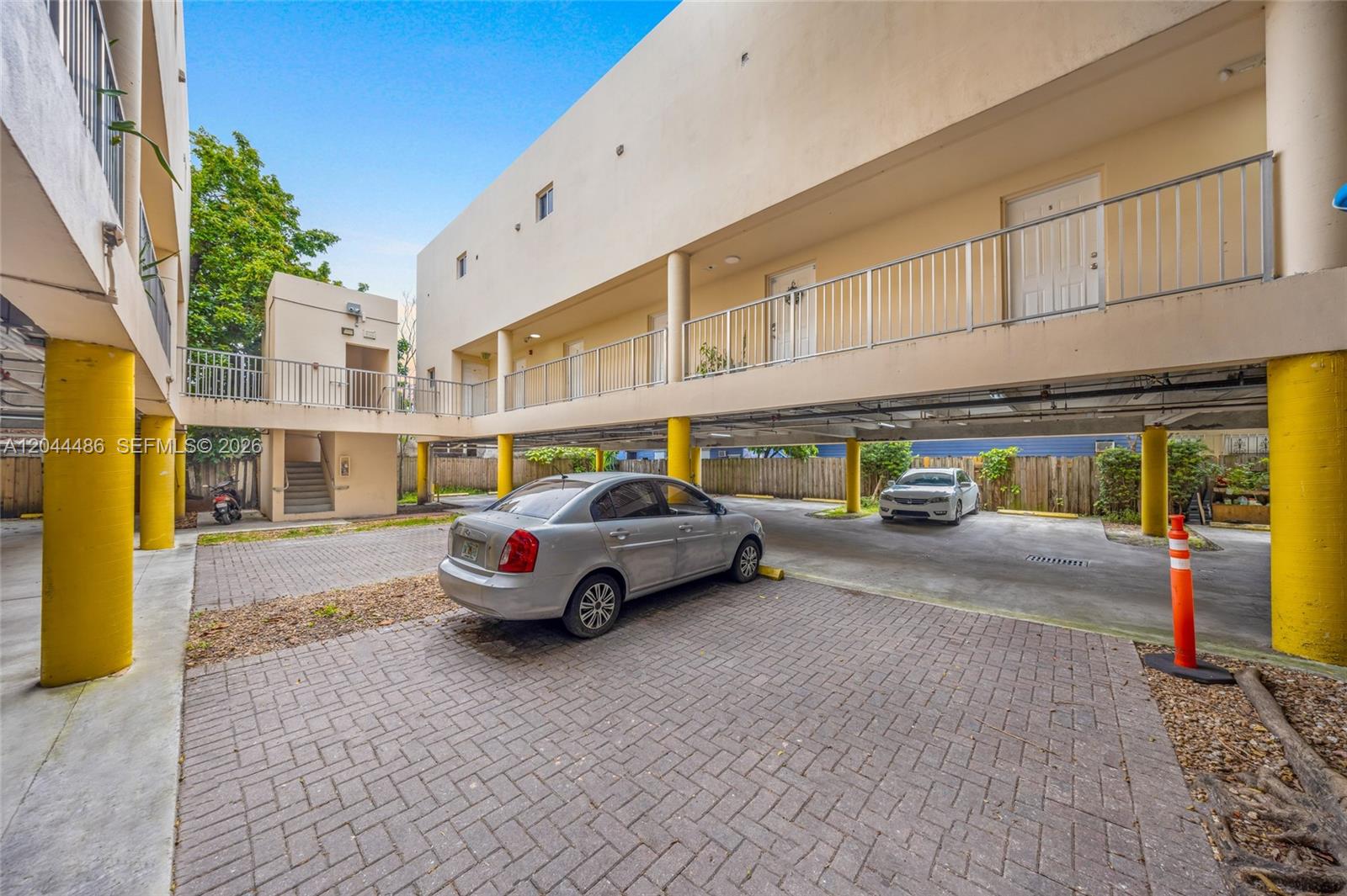 An exterior view shows a multi-story apartment building with covered parking and yellow support columns — 1553 SW 2nd St, Miami FL 33135, MIAMI, FL
