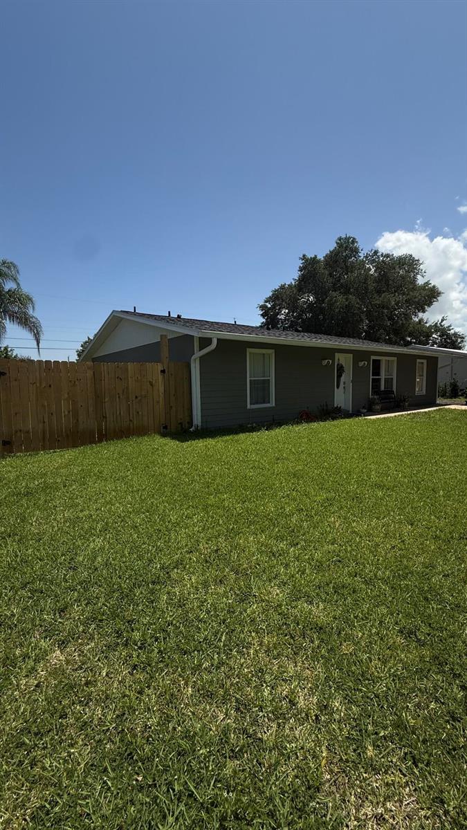 A gray, single-story house with a white front door, black bench, and a concrete driveway — 433 20th Street SW, Vero Beach FL 32962, VERO BEACH, FL