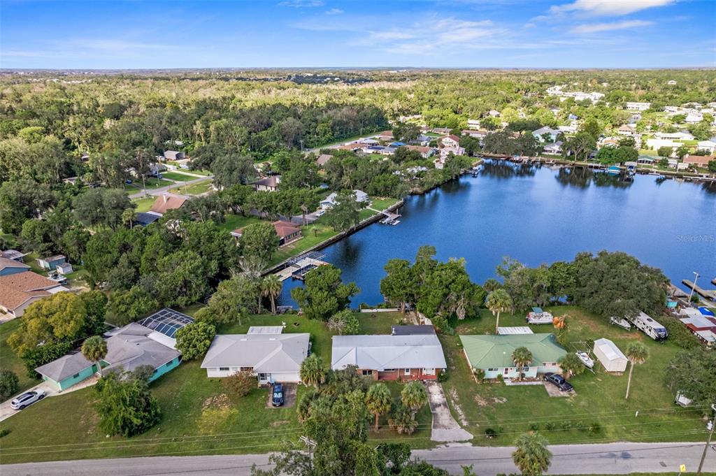 An aerial view shows several waterfront houses with docks along a lake surrounded by trees — 3902 N TALLAHASSEE ROAD, CRYSTAL RIVER, FL