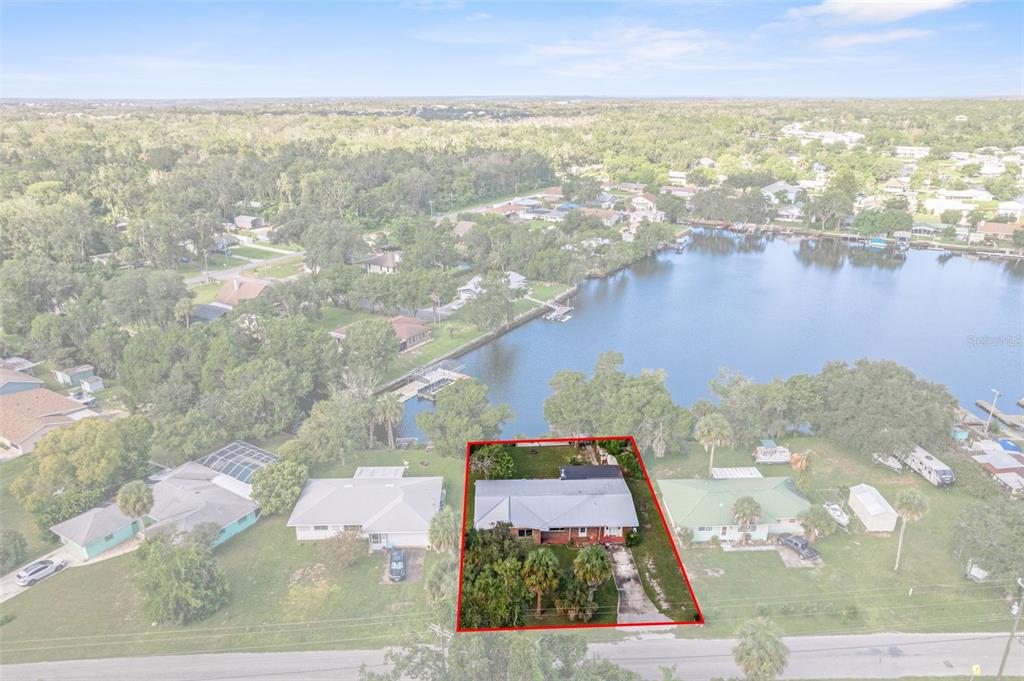 An aerial view shows a single-story house with a red-outlined lot near a lake — 3902 N TALLAHASSEE ROAD, CRYSTAL RIVER, FL
