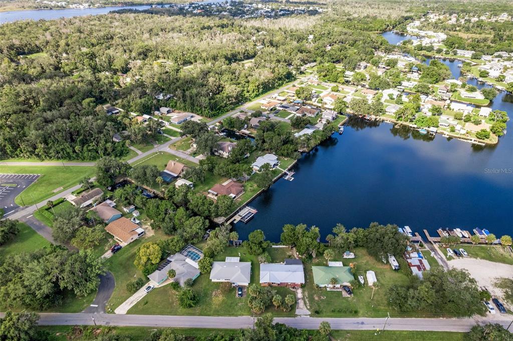 An aerial view shows waterfront houses with private docks along a canal and lake — 3902 N TALLAHASSEE ROAD, CRYSTAL RIVER, FL