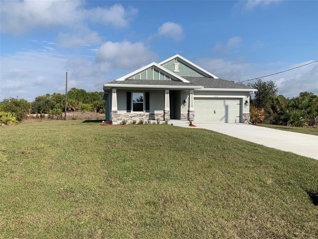 A single-story house with a stone-accented facade, a front porch, and an attached garage — 12132 BACCHUS ROAD, PORT CHARLOTTE, FL