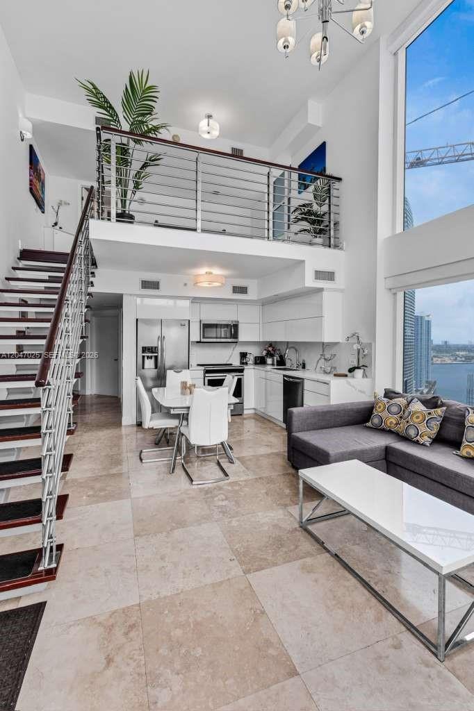 A modern two-story apartment with a loft, open kitchen, dining area, and floor-to-ceiling windows — 41 SE 5th St # 1702, Miami FL 33131, MIAMI, FL