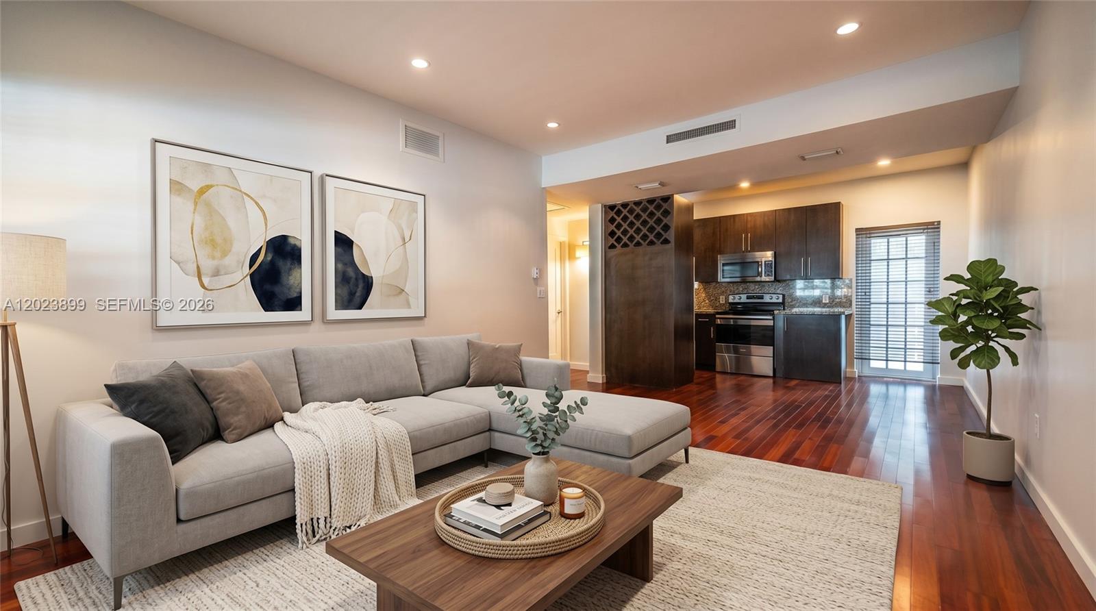 A living room with a gray sectional sofa opens into a kitchen with dark cabinetry — 1438 Meridian Ave, Miami Beach FL 33139, MIAMI BEACH, FL