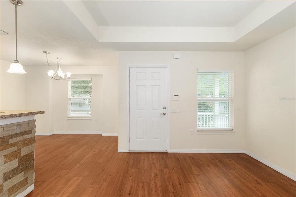 A room with wood-look flooring, a white front door, and a window with blinds — 2776 SE 21ST ROAD, GAINESVILLE, FL