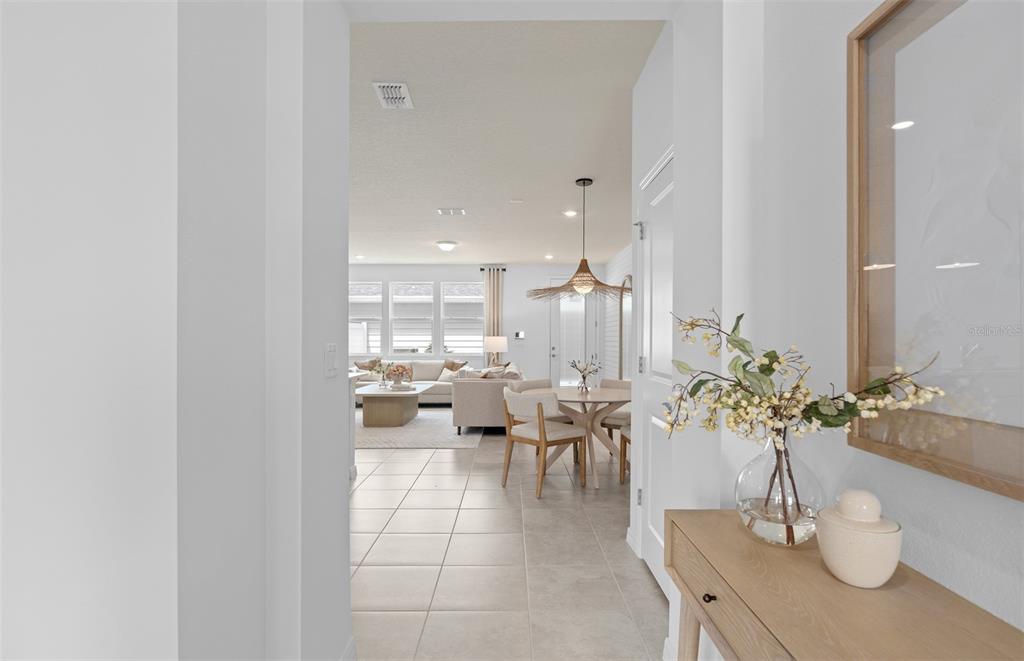 A view through a doorway into a bright, open-concept living and dining area — 10130 HADLEY STREET, ORLANDO, FL