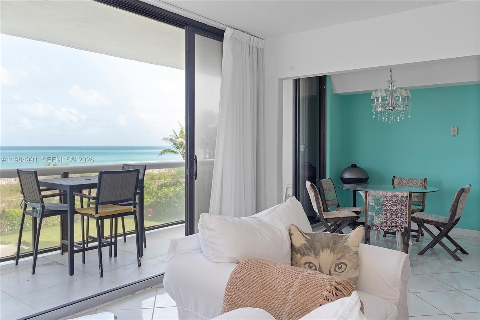 A living room with a balcony overlooking the ocean and a separate dining area — 9455 Collins Ave # 409, Surfside FL 33154, SURFSIDE, FL