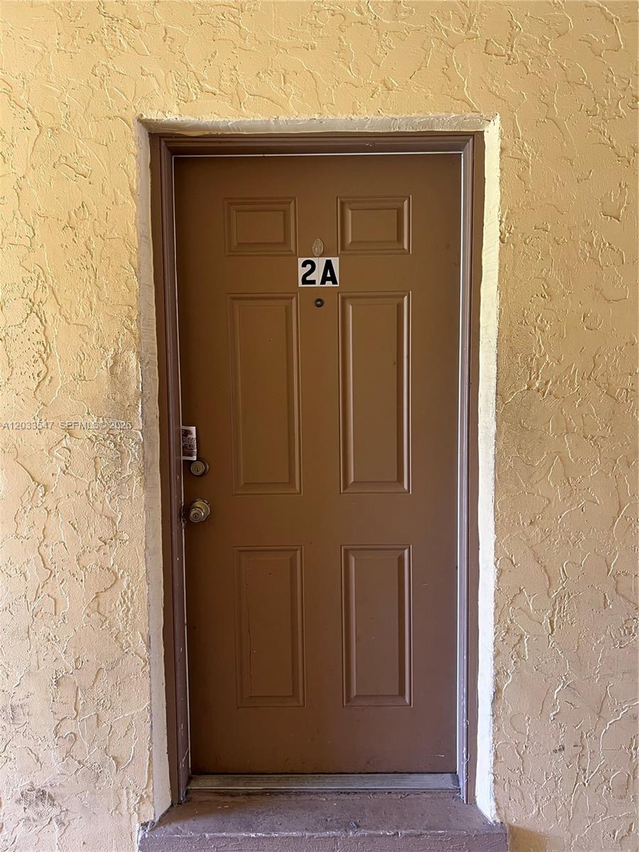 A brown door labeled 2A is set into a textured, light-colored stucco exterior wall — 2916 NW 55th Ave # 2A, Lauderhill FL 33313, LAUDERHILL, FL