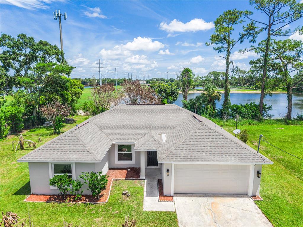 An aerial view of a single-story house with a gray roof, garage, and waterfront backyard — 201 RONNIE CIRCLE, ORLANDO, FL