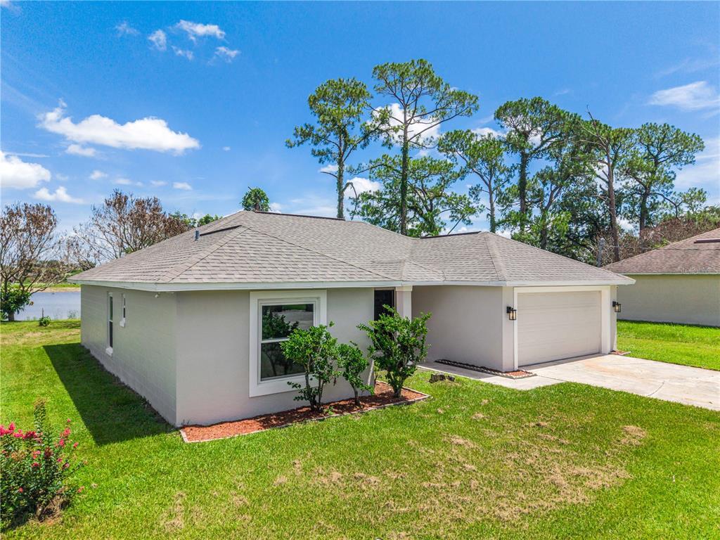 A single-story house with a gray roof, light-colored stucco exterior, and an attached garage — 201 RONNIE CIRCLE, ORLANDO, FL