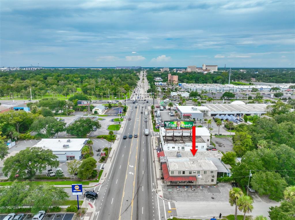 An aerial view shows a commercial building with a flat roof and a large billboard — 936 W INTERNATIONAL SPEEDWAY BOULEVARD, DAYTONA BEACH, FL