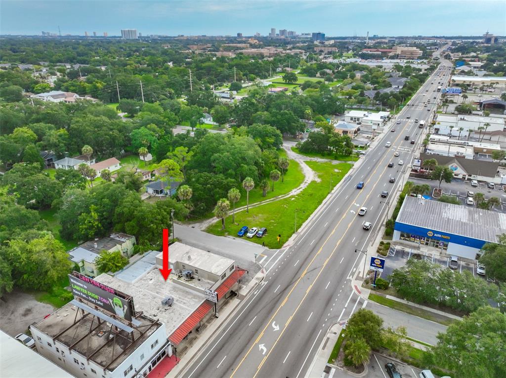 An aerial view shows a commercial building with a billboard and a red arrow pointing down — 936 W INTERNATIONAL SPEEDWAY BOULEVARD, DAYTONA BEACH, FL